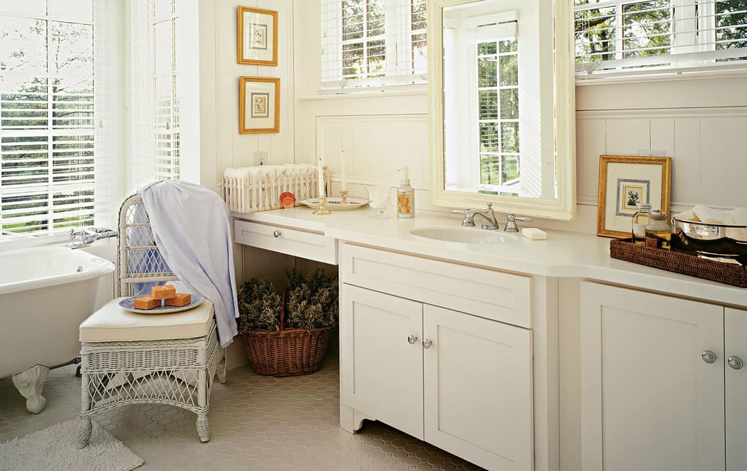 Traditional bathroom remodel with furniture-style vanity, framed mirror and tiled floor