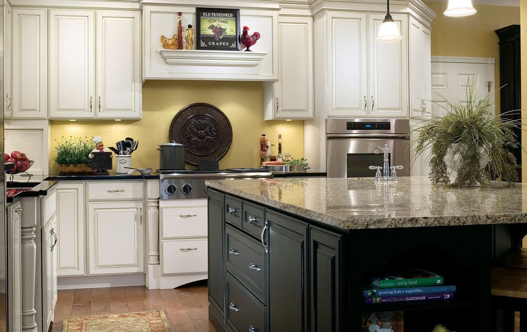 Two-tone kitchen with dark base cabinets, stainless appliances and quartz countertops