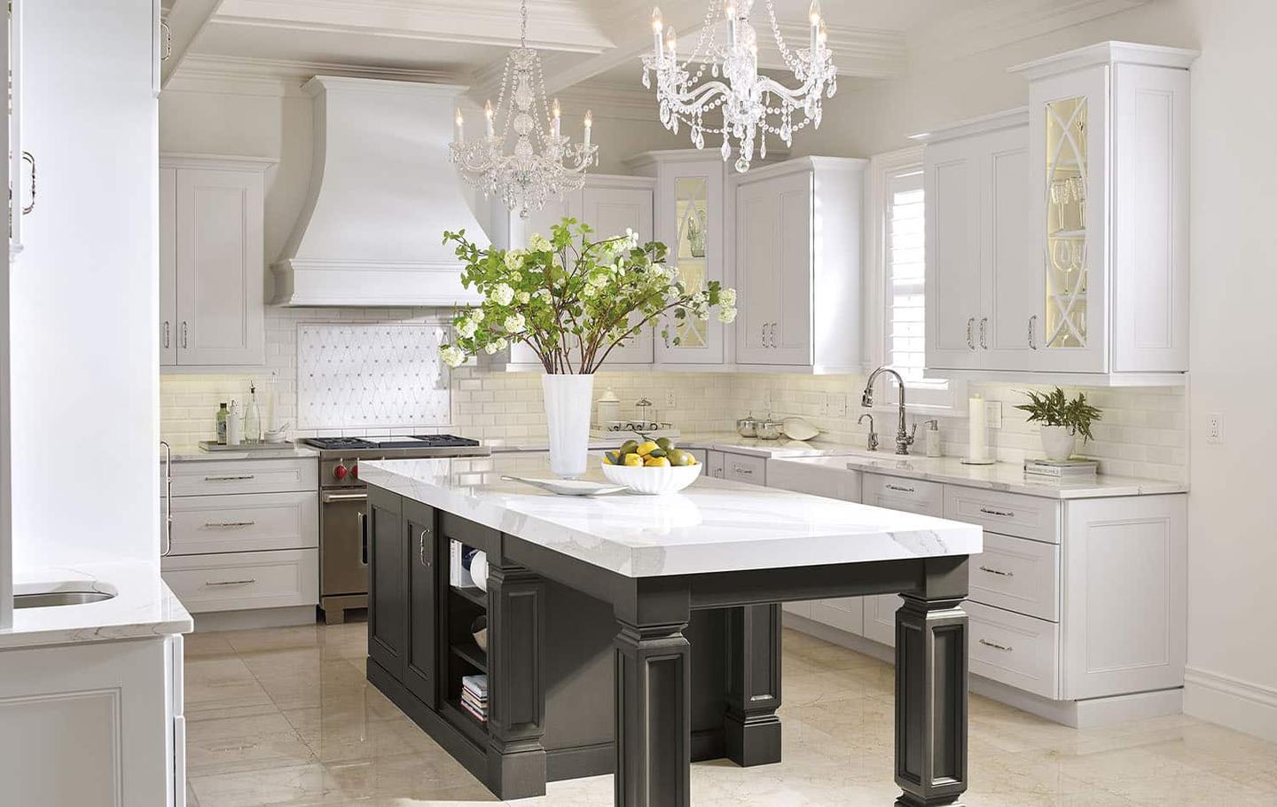 White kitchen with a chandelier and a large marble-topped island