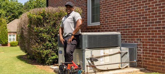 A Man Sitting In Front Of A Brick Building